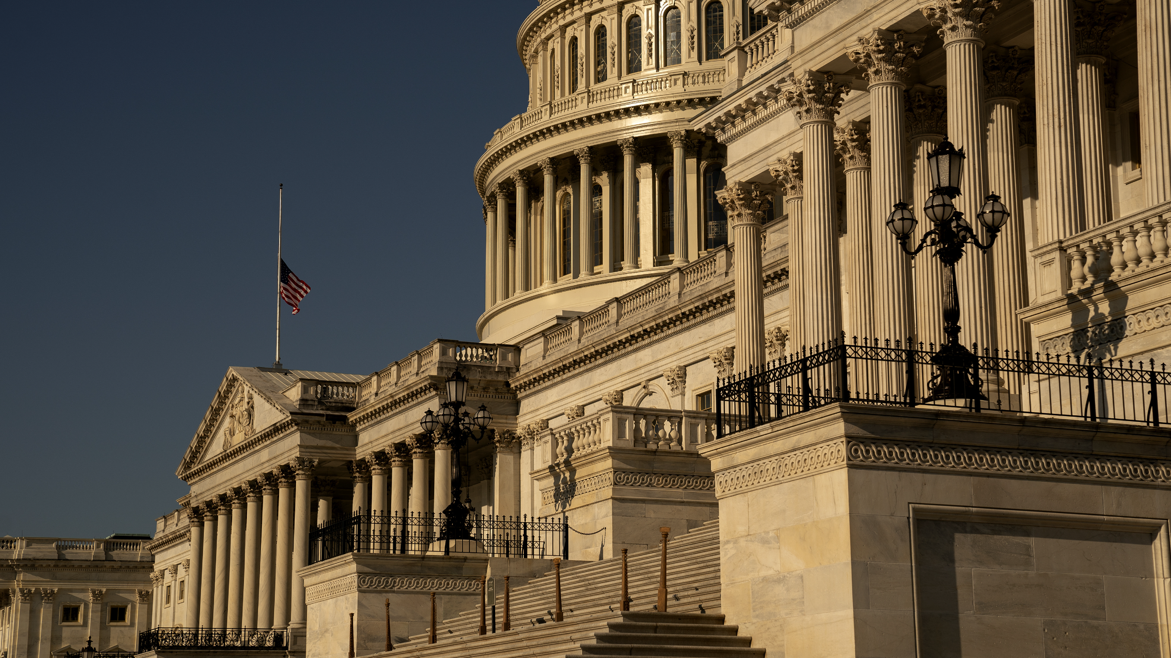 The dome and east front of the United States Capitol lit by low evening sun