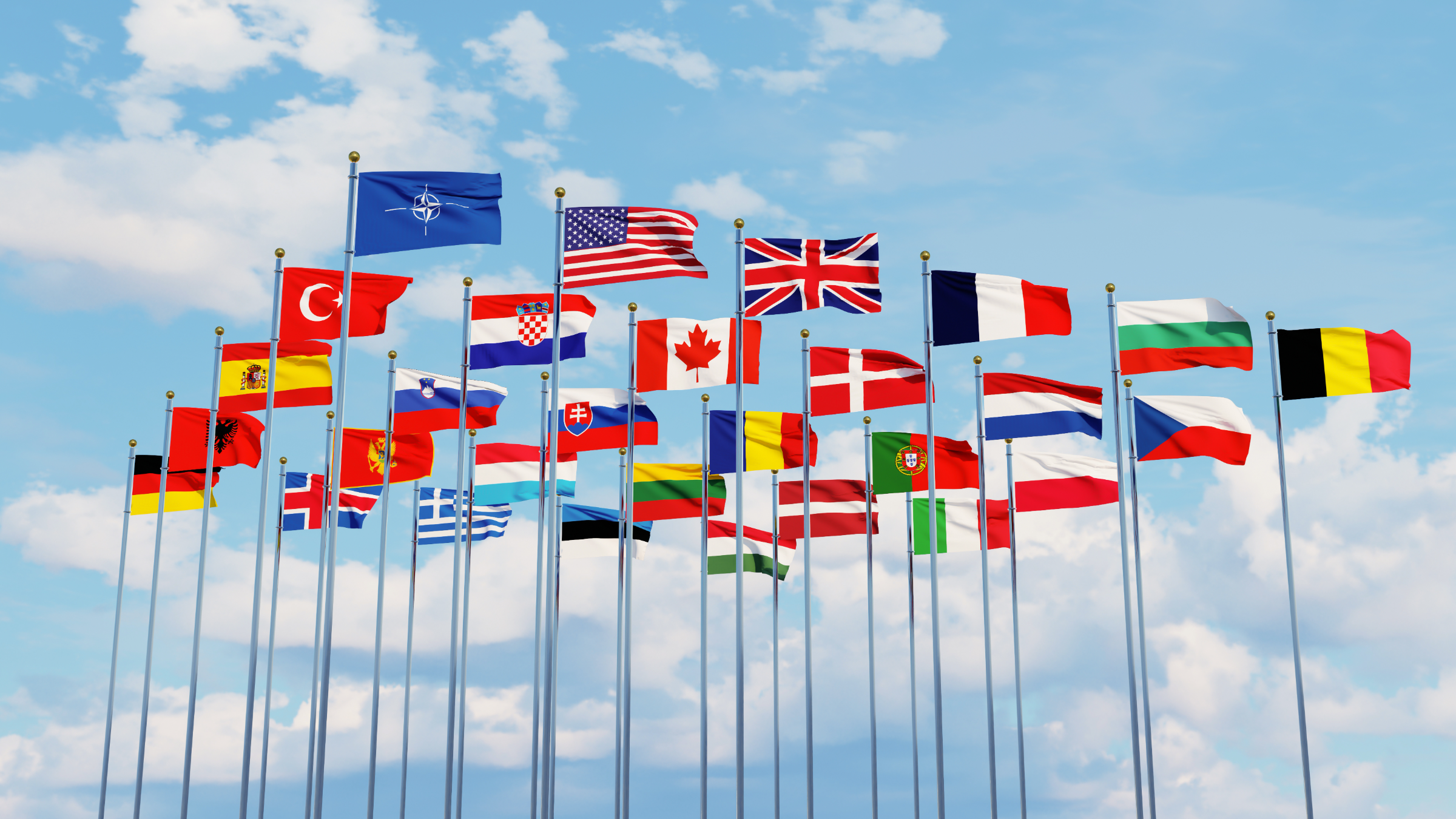 The NATO flag flying alongside the national flags of allied member countries